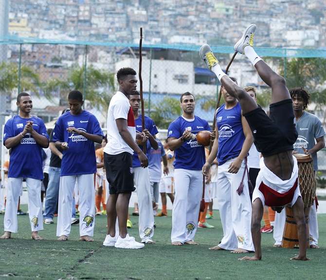 England's Danny Welback,right, performs capoeira as teammate Daniel Sturridge looks