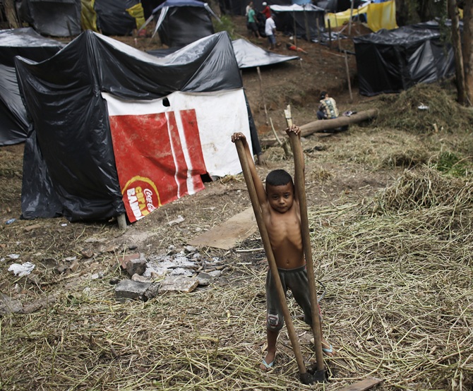 The son of a member of the Brazil's Homeless Workers' Movement (MTST) plays with hoes at the 'People's World Cup' camp
