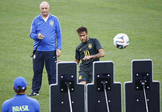 Brazil's national soccer team coach Luiz Felipe Scolari looks on as his striker Neymar practises free kicks during their final practice at the Arena de Sao Paulo in Sao Paulo on Wednesday