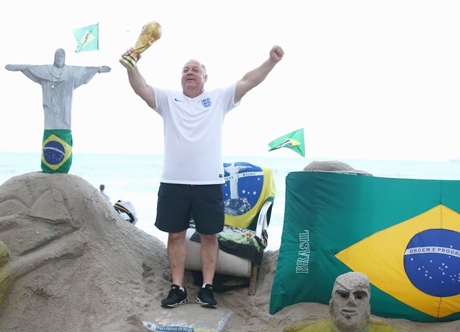 An England fan holds a replica world cup trophy at Copacabana beach in Rio de Janeiro, Brazil