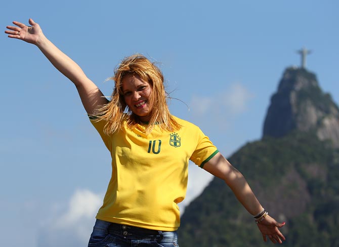 A Brazil fan poses for a photo near the Christ Redeemer in Rio de Janeiro