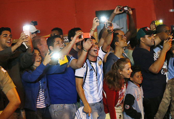 Fans click pictures of Argentina's team bus upon their arrival at Independencia stadium before the start of a training session on Wednesday