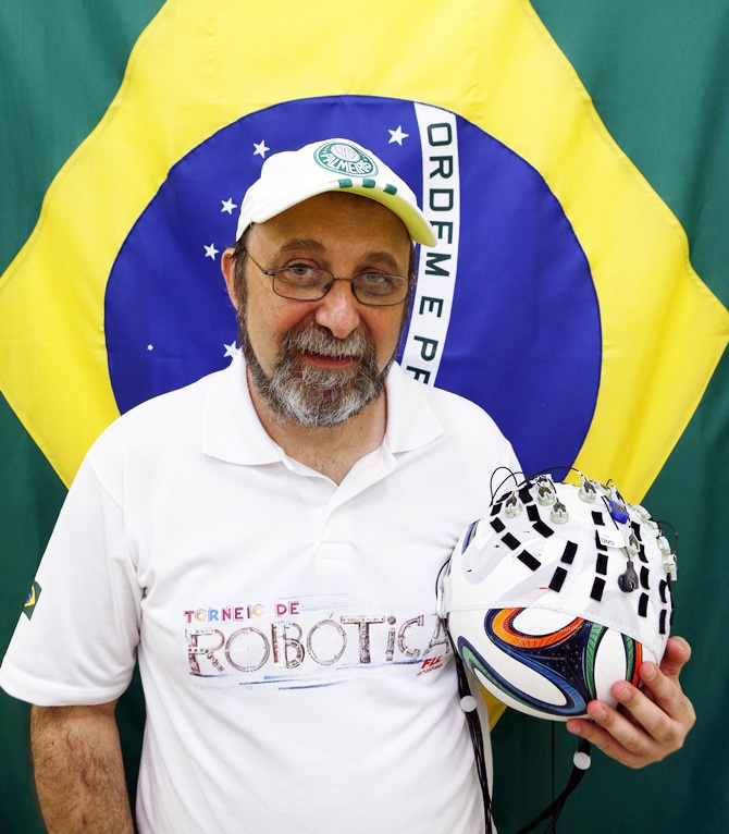 Brazilian neuroscientist Miguel Nicolelis holds a soccer ball covered with a hood of electronic sensors in Sao Paulo