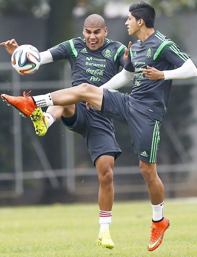 Mexico's national soccer team players Alan Pulido,right, and Carlos Salcido fight for the ball during a training session