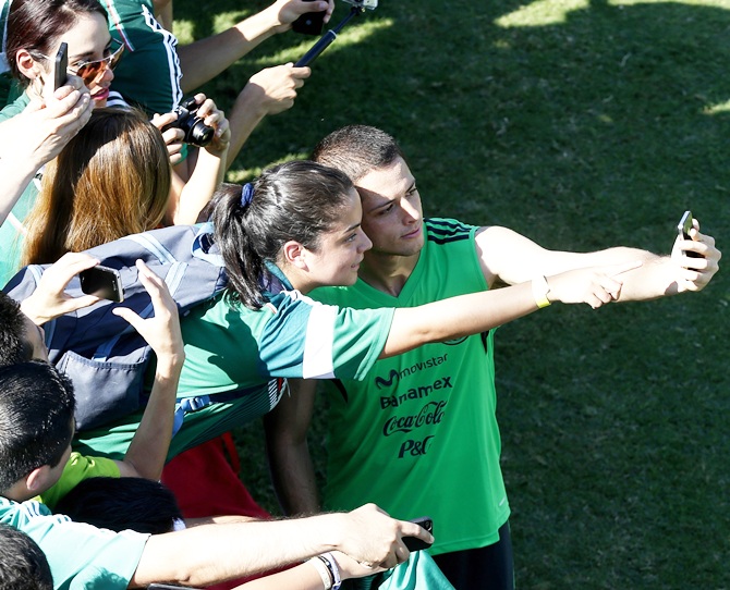 Mexico soccer playe Javier Hernandez poses for a picture with a fan