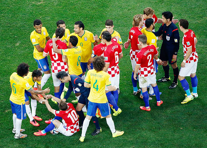 Brazil and Croatia players converge on referee Yuichi Nishimura after a foul and yellow card was shown to Brazil's Neymar during their match  on Thursday