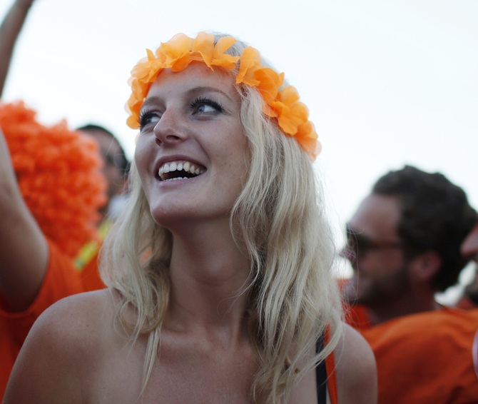 A Dutch soccer fan watches the 2014 World Cup soccer match between the Netherlands and Spain on a large screen at Copacabana beach