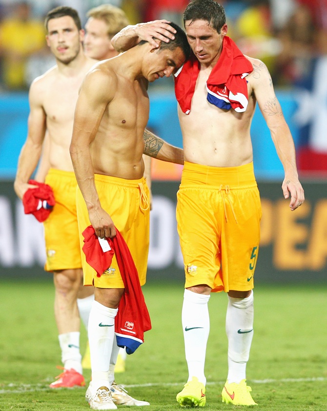 Tim Cahill, left, and Mark Milligan of Australia embrace after being defeated by Chile