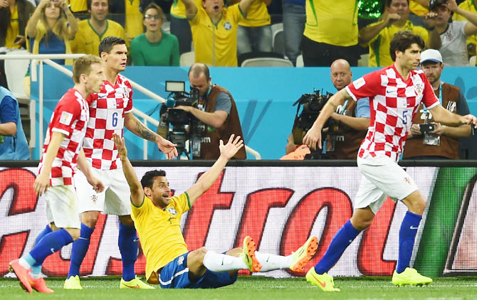 Fred of Brazil sits on the field gesturing for a foul against Dejan Lovren of Croatia during the 2014 FIFA World Cup Brazil Group A match on Thursday