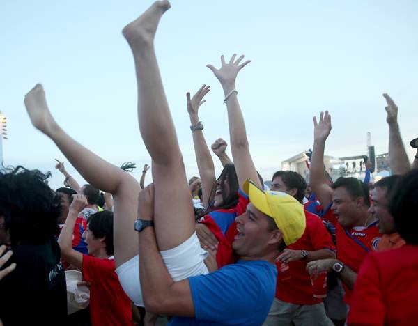 Costa Rican fans react to the first goal their team scored against Uruguay while watching the game on the giant screen showing the match at the FIFA World Cup Fan Fest on Copacabana beach