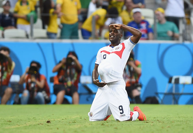 Joel Campbell of Costa Rica celebrates scoring his team's first goal with the ball under his jersey