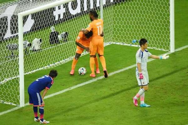 Wilfried Bony of the Ivory Coast (second from left) celebrates scoring his team's first goal with Didier Drogba of the Ivory Coast as goalkeeper Eiji Kawashima of Japan reacts and Atsuto Uchida looks on.