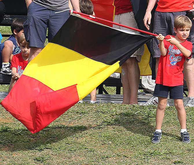 A young Belgium fan waves the country's national flag as he watches the team during a training session