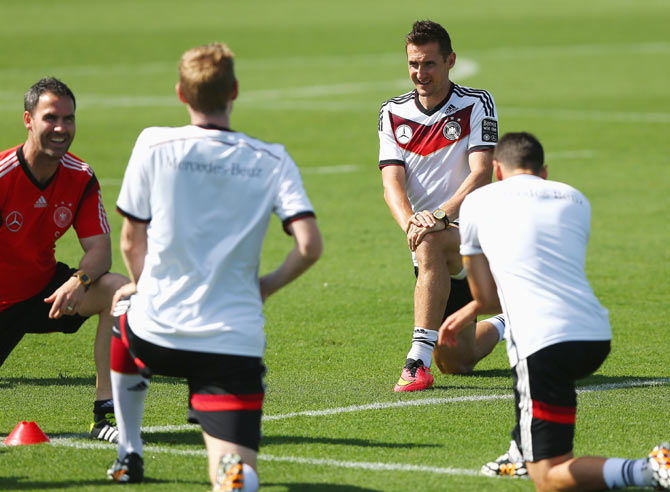 Miroslav Klose (right) stretches during the German National team training session at Campo Bahia in Santo Andre, Brazil