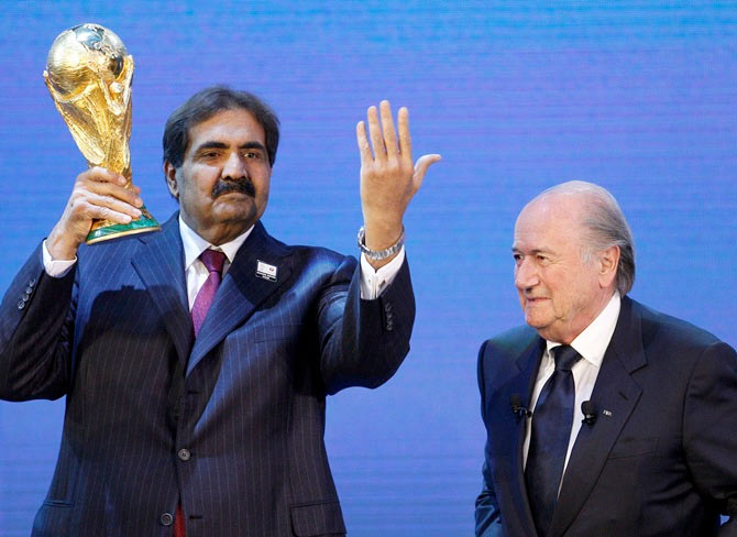Qatar's Emir Sheikh Hamad bin Khalifa al Thani (left) holds up a copy of the World Cup he received from FIFA President Sepp Blatter