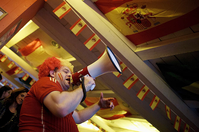 A waiter uses a megaphone to cheer Spanish soccer fans watching their team playing against the Netherlands in a Madrid tavern on Friday