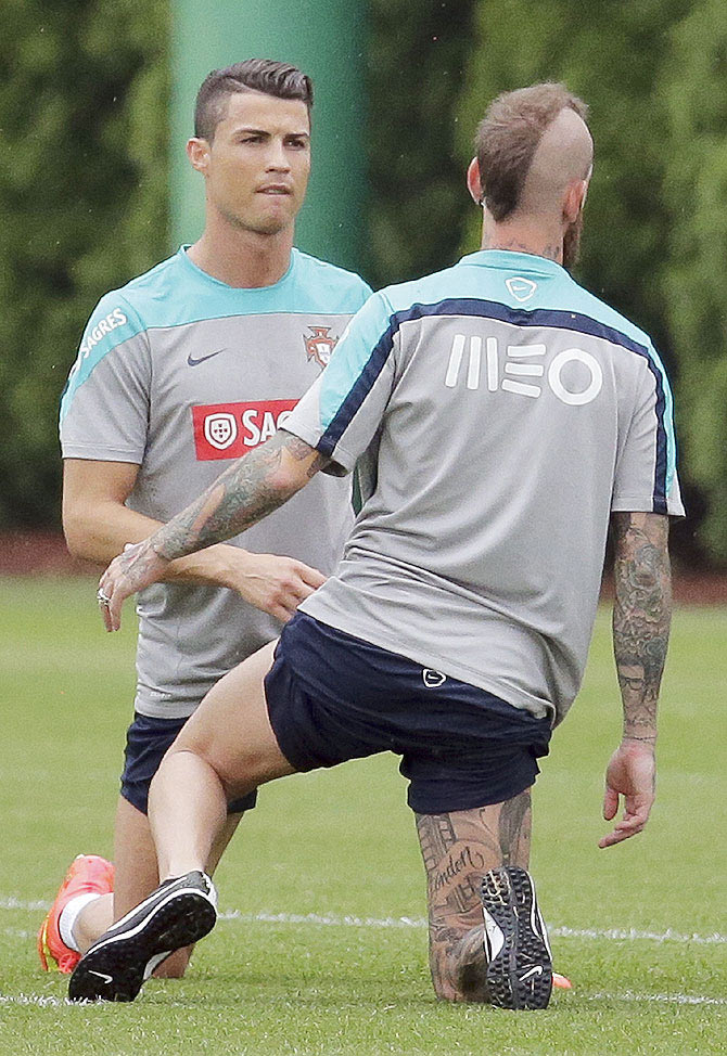 Cristiano Ronaldo (left) of Portugal stretches with teammate Raul Meireles as they practice