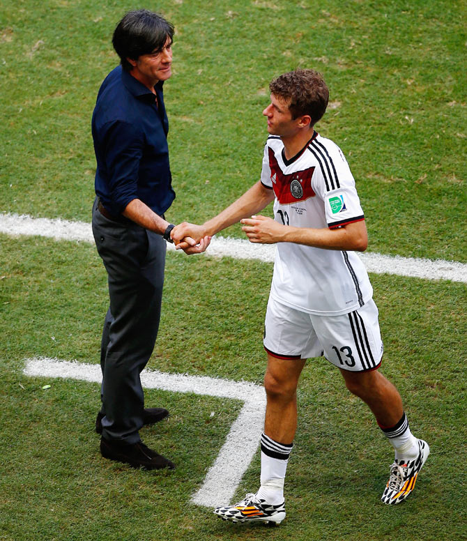 Head coach Joachim Loew of Germany shakes hands with Thomas Mueller as he exits the game after scoring a hat-trick against Portugal in their Group G match at Arena Fonte Nova in Salvador, Brazil on Monday