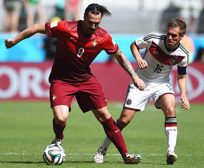 Hugo Almeida of Portugal dribbles past Philipp Lahm of Germany during theirWorld Cup Group G match at Arena Fonte Nova in Salvador on Monday