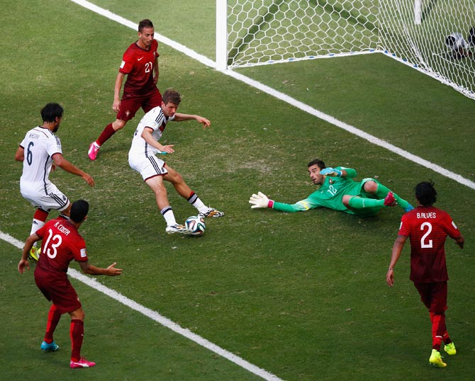 Thomas Mueller of Germany (centre) scores his team's fourth goal and completes his hat trick past Portugal goalkeeper Rui Patricio