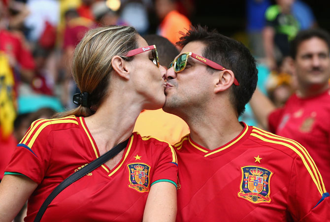 Two Spain fans kiss before the Group B match against Netherlands at Arena Fonte Nova