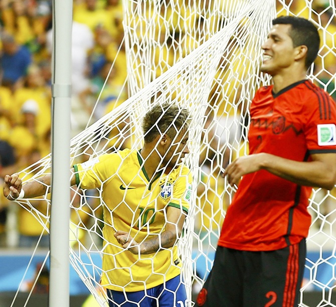 Brazil's Neymar holds the net after a failed attempt at the goal, as Mexico's Francisco Rodriguez smiles
