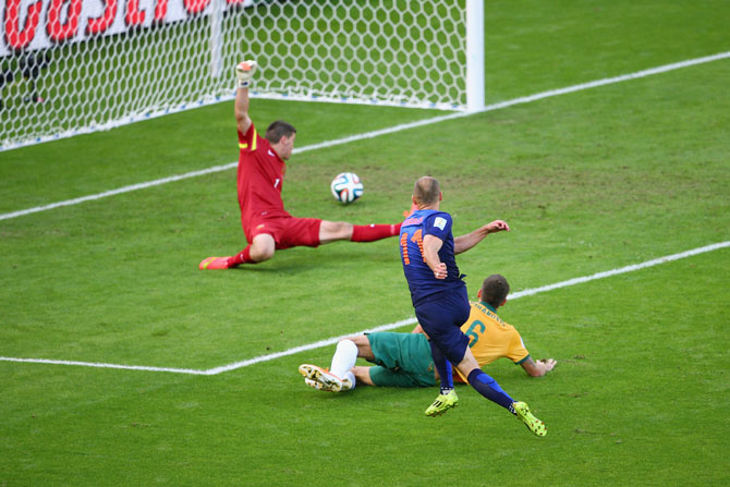 Arjen Robben of the Netherlands shoots and scores his team's first goal past goalkeeper Mathew Ryan of Australia