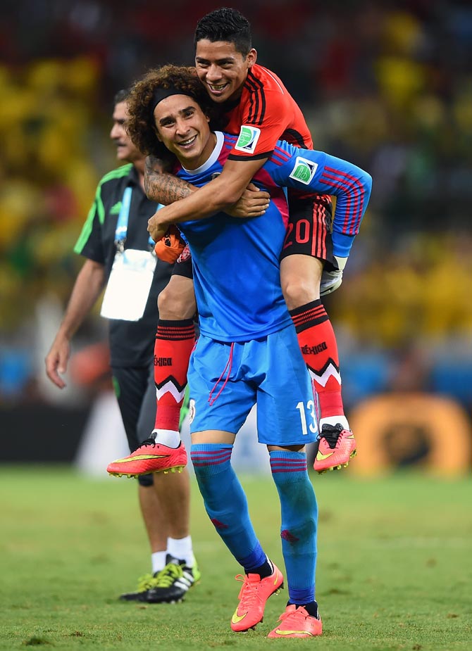 Goalkeeper Guillermo Ochoa of Mexico celebrates with Javier Aquino after their 0-0 draw with Brazil