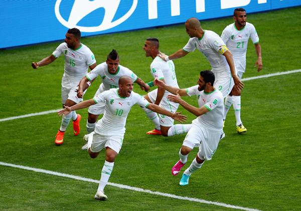 Sofiane Feghouli (No 10) of Algeria celebrates with his teammates after scoring his team's first goal from a penalty kick