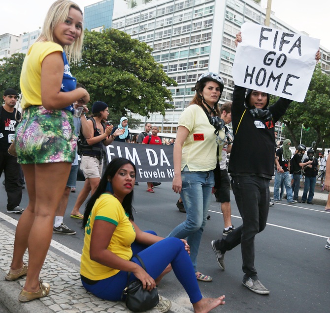 A protestor holds a 'FIFA Go Home' sign during an anti-World Cup demonstration in the Copacabana section