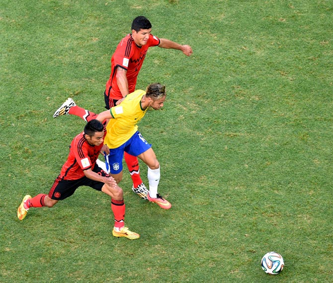 Neymar of Brazil takes on Jose Juan Vazquez of Mexico and Francisco Javier Rodriguez 