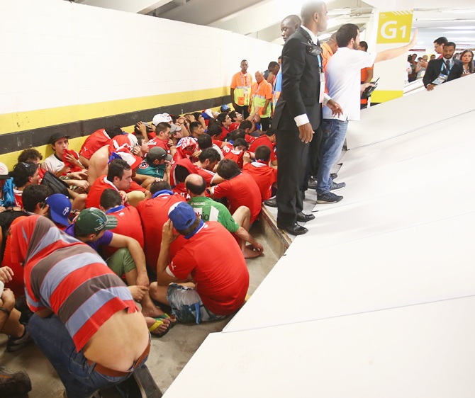 Security personnel attempt to control fans after breaking through security and   attempting to enter the stadium prior to the 2014 FIFA World Cup