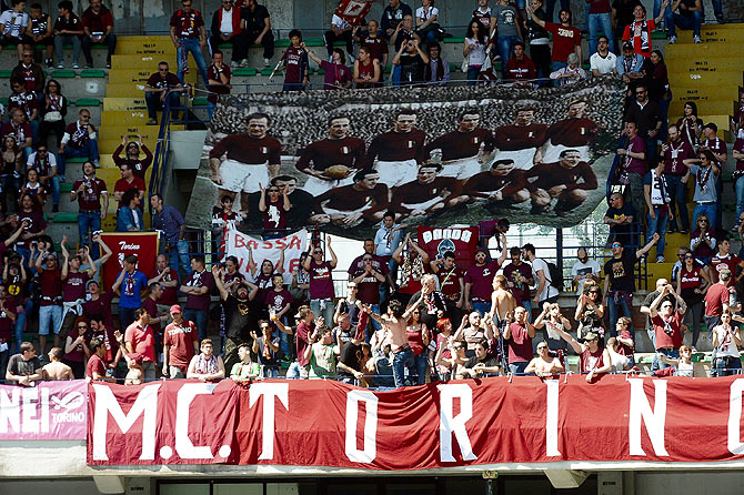 Supporters of Torino FC hold a banners commemorating the Torino players who lost their lives when their plane crashed in what is known as the Superga air disaster, on the 65th anniversary of the tragedy during the Serie A match between AC Chievo Verona and Torino FC at Stadio Marc'Antonio Bentegodi on May 4, 2014 in Verona, Italy