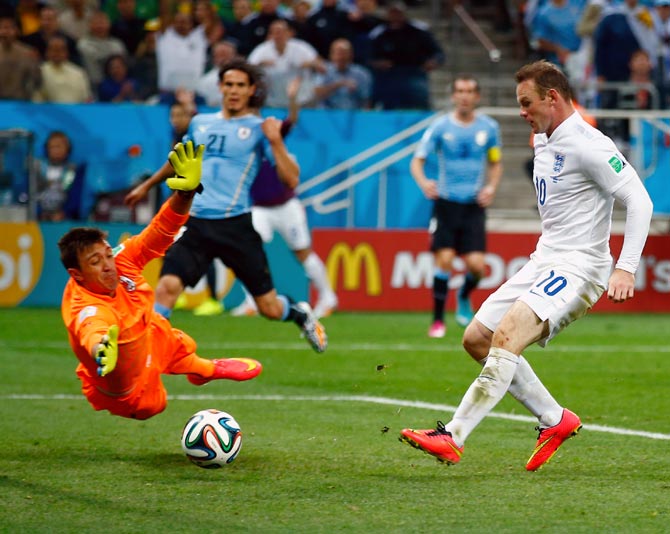Wayne Rooney of England scores his team's first goal past Uruguay goalkeeper Fernando Muslera