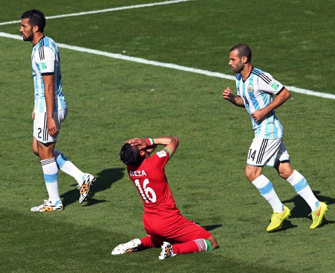 Reza Ghoochannejhad (centre) of Iran reacts after a missed chance