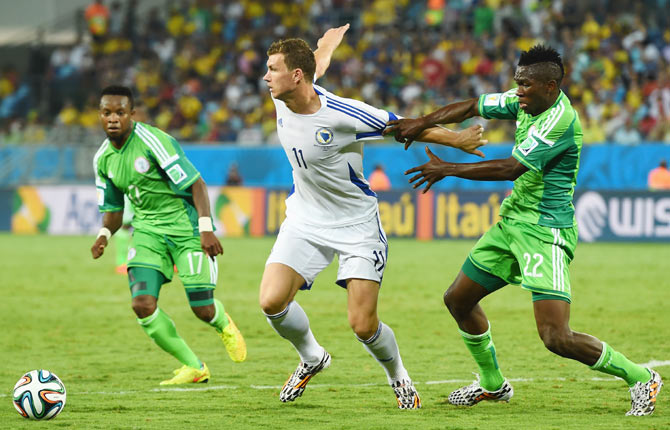 Edin Dzeko of Bosnia and Herzegovina and Kenneth Omeruo of Nigeria compete for the ball during their match on Friday