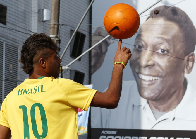 Thiago Silva plays with a soccer ball in front of Brazil's Santos soccer team stadium where soccer legend Pele played during his career