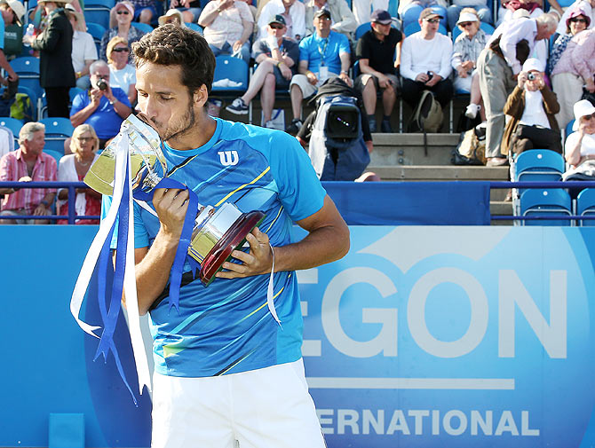 Feliciano Lopez of Spain celebrates with the trophy after beating Richard Gasquet of France during their Men's Singles final of the Aegon International at Devonshire Park on Saturday