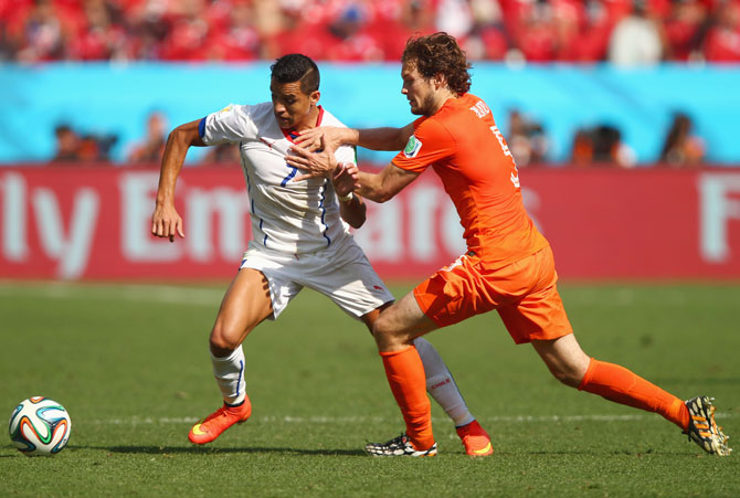 Alexis Sanchez of Chile and Daley Blind of the Netherlands compete for the ball