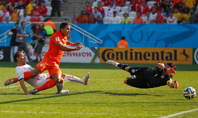 Memphis Depay of the Netherlands shoots and scores his team's second goal past goalkeeper Claudio Bravo of Chile