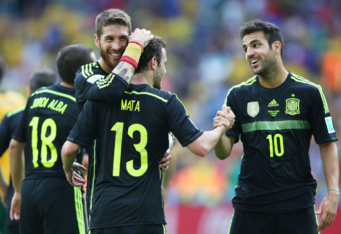 Juan Mata of Spain (centre) celebrates scoring his team's third goal with teammates Sergio Ramos (left) and Cesc Fabregas