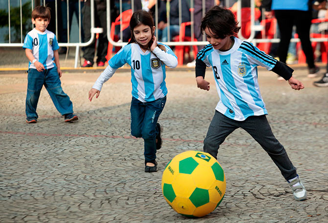 Children wearing Argentina jerseys play soccer at a FIFA public viewing area in Sao Paulo.