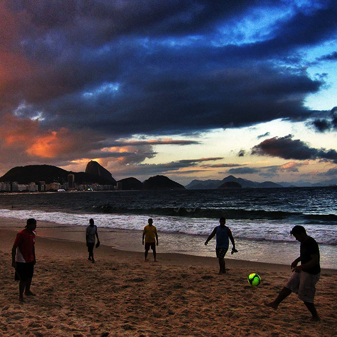 Beachgoers play football on Copacabana Beach in Rio de Janeiro.