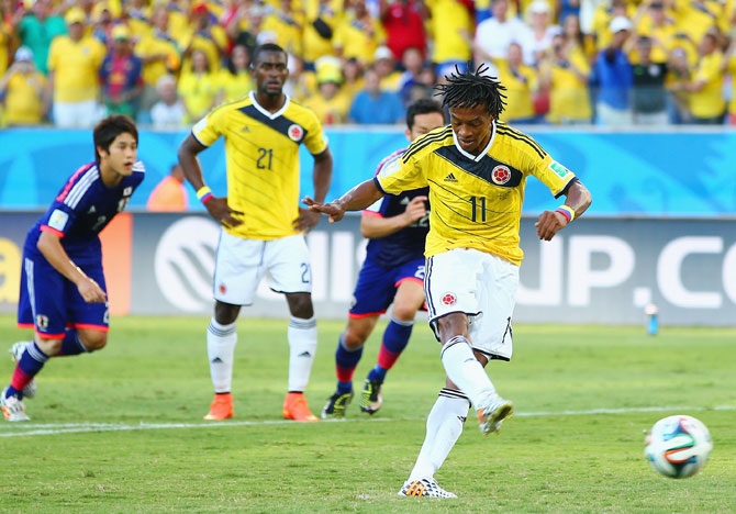 Juan Guillermo Cuadrado of Colombia shoots and scores his team's first goal on a penalty kick