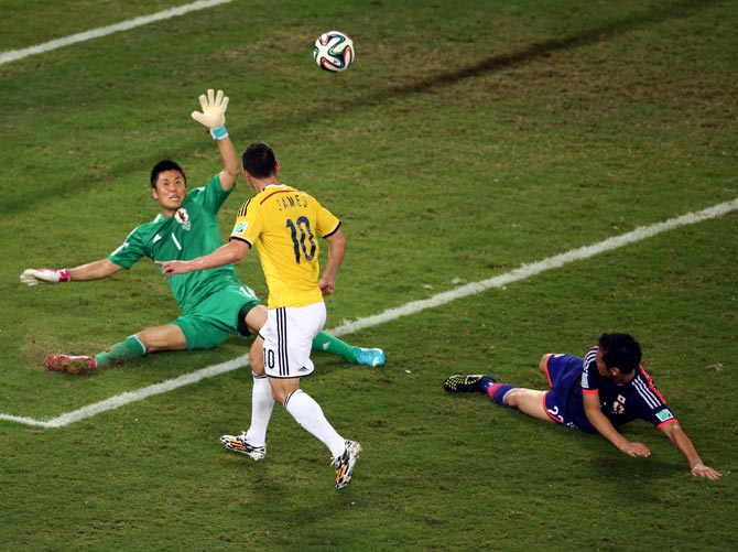 James Rodriguez of Colombia shoots and scores his team's fourth goal past goalkeeper Eiji Kawashima of Japan.