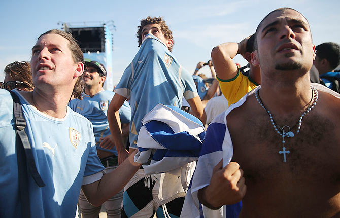 Uruguay football fans watch the Group D World Cup match between Uruguay and Italy at Copacabana beach in Rio de Janeiro on Tuesday