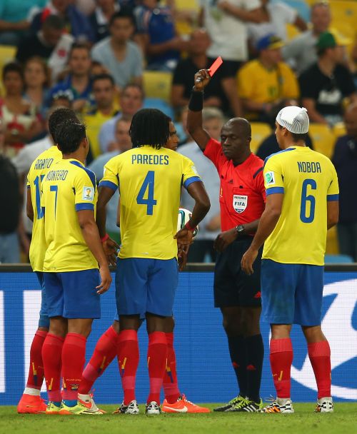 Antonio Valencia of Ecuador (obscured) is shown a red card by referee Noumandiez Doue