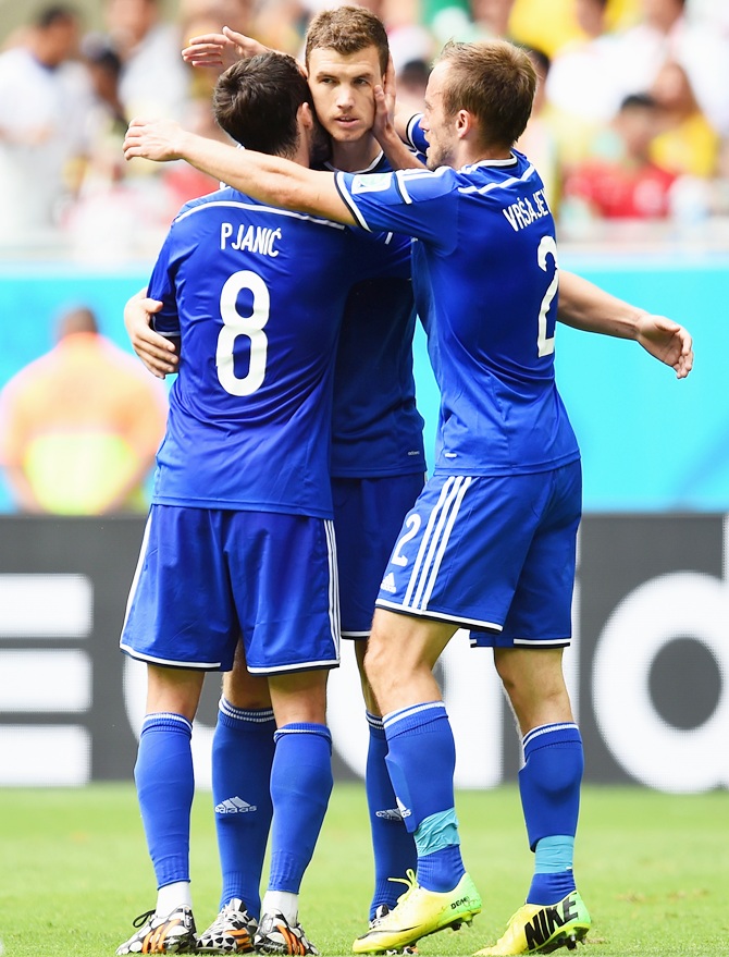 Edin Dzeko of Bosnia and Herzegovina, center, celebrates scoring his team's first goal