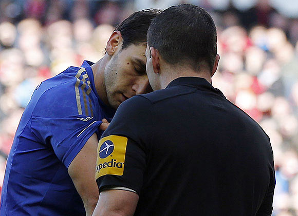 Chelsea's Branislav Ivanovic (left) shows his arm to referee Kevin Friend   after Liverpool's Luis Suarez bit him during their English Premier League soccer match at Anfield in Liverpool on April 21, 2013