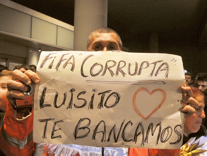 A Uruguay's fan shows a sign in solidarity withLuis Suarez. Sign reads 'FIFA corrupt - Luis, we love and back you'
